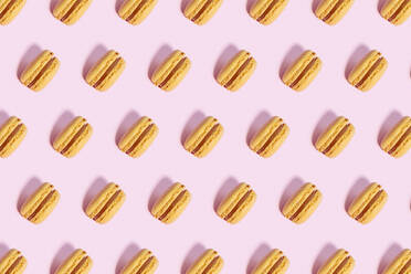 Pattern of yellow macaroon cookies against pink background - GEMF04552