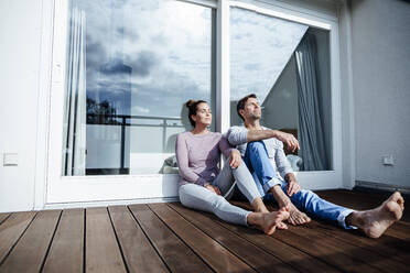 Mature couple relaxing in balcony on sunny day - JOSEF02831