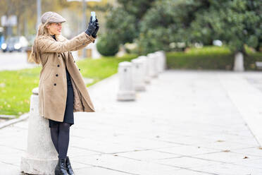 Schöne Frau, die ein Selfie macht, während sie auf dem Fußweg steht - GGGF00698