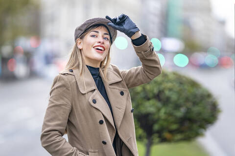 Attractive woman holding cap while looking away stock photo