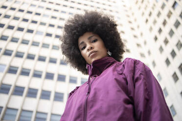 Junge Afroamerikanerin mit ausdruckslosem Gesicht, die vor einem Gebäude steht - IFRF00265