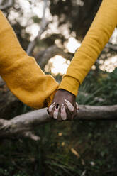 Nahaufnahme eines händchenhaltenden Paares im Wald - EGAF01359