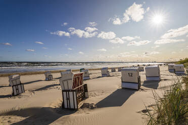 Germany, Mecklenburg-Western Pomerania, Ahlbeck, Hooded beach chairs on sandy coastal beach - WDF06458