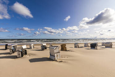 Germany, Mecklenburg-Western Pomerania, Ahlbeck, Hooded beach chairs on sandy coastal beach - WDF06459