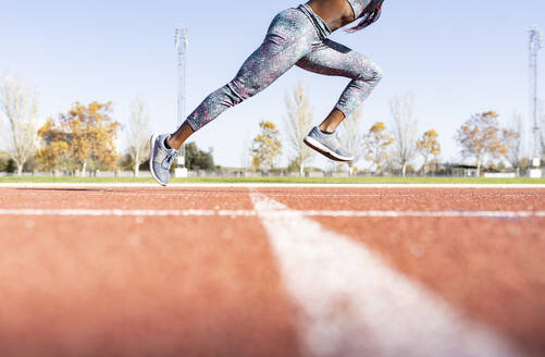 Weibliche Sportlerin läuft an einem sonnigen Tag auf einer Sportbahn - JCCMF00528