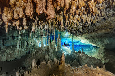 Male diver exploring amidst rock formation in sea, Cenote Nariz, Quintana Roo, Mexico - YRF00240