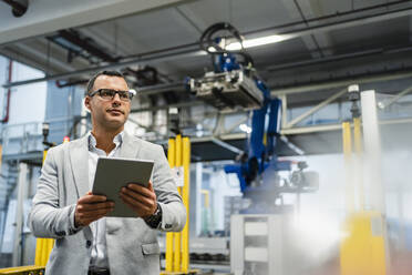 Manager holding digital tablet while looking around in industry - DIGF14005