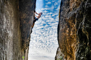 Junger Mann klettert seilfrei an einer vertikalen Wand - CAVF91435