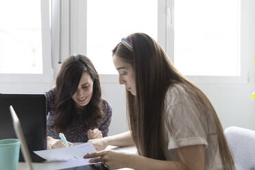 Female managers analyzing paper together - CAVF91446