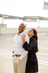 Multiracial Late Forties Couple Embracing at Sunset in San Diego - CAVF91479