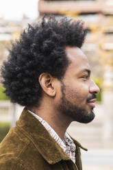 Nahaufnahme eines nachdenklichen, erwachsenen Mannes mit Afro-Haar, der wegschaut - PNAF00482