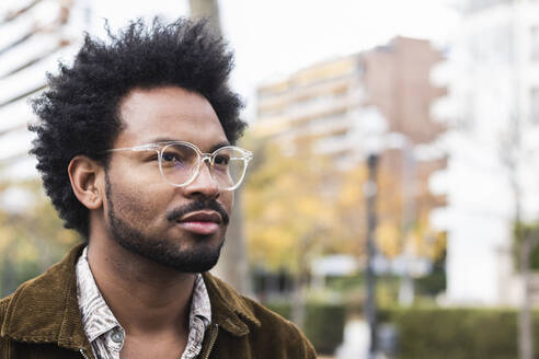 Nahaufnahme eines nachdenklichen Mannes mit Afro-Haar und Brille - PNAF00484