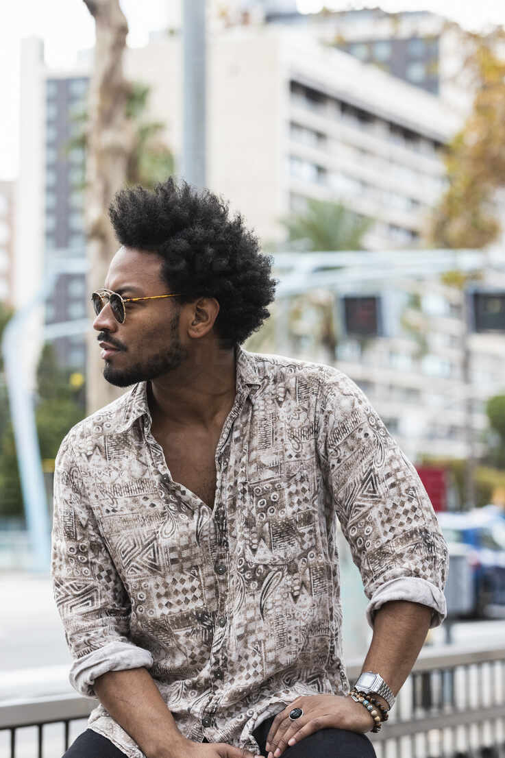 Stylish mid adult man with afro hair wearing sunglasses while