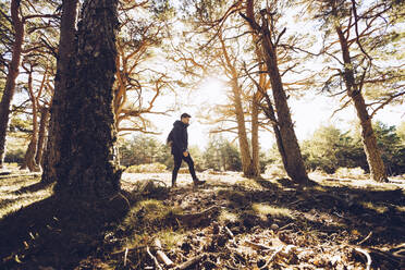 Männlicher Wanderer, der in einem Waldgebiet spazieren geht - RSGF00473
