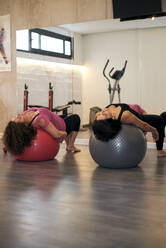 Zwei Frauen mittleren Alters spielen Pilates-Ball - CAVF91519