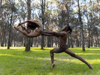 Two professional dancers performing in underwear in middle of forest - JCCMF00596