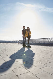 Junger Mann mit Frau auf dem Pier stehend gegen den Himmel an einem sonnigen Tag - VEGF03524