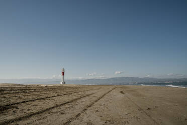 Klarer Himmel über leeren Platja del Fangar Strand mit Far del Fangar Leuchtturm im Hintergrund - AFVF08038