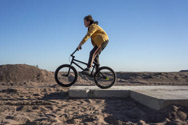 Boy riding BMX on sand - VPIF03411