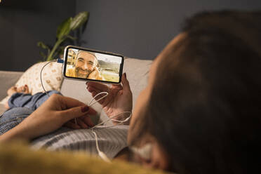 Smiling mature man on video call with woman through mobile phone - UUF22384