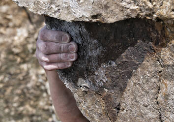 Hand eines jungen Mannes beim Klettern auf einen Felsen - ALRF01779