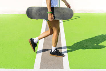 Tiefschnitt einer erwachsenen Frau mit Skateboard - PGF00382