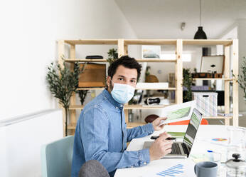 Portrait of business man wearing protective mask working in office  - GIOF10427