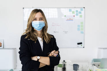 Portrait of business woman wearing protective mask in office  - GIOF10451