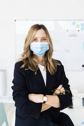 Portrait of business woman wearing protective mask in office  - GIOF10452