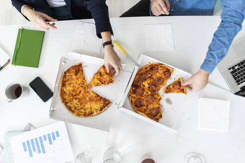 Geschäftsleute essen in der Pause Pizza im Büro - GIOF10456