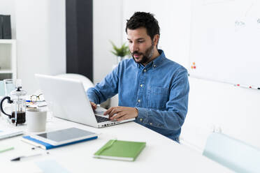 Man using laptop in office - GIOF10462