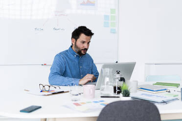 Man using laptop in office - GIOF10463