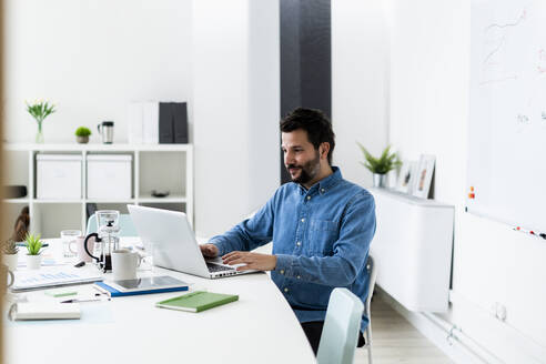 Man using laptop in office - GIOF10465