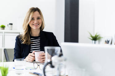 Portrait of smiling business woman in office - GIOF10476