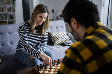Woman and man playing chess at home - GIOF10520