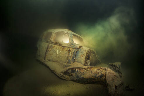 Underwater view of rusty car wreck deteriorating at bottom of Lake Atter - YRF00267