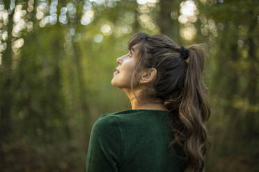 Modische junge Frau, die im Herbst in einem Park steht und nachdenkt - AXHF00032