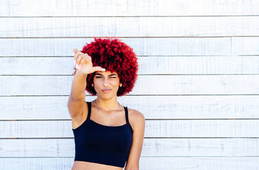 Porträt einer Frau mit rotem Afro-Haar auf weißem Hintergrund. - CAVF91574