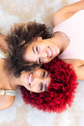 Zenithal portrait of two latin women with afro hair on the ground. - CAVF91582