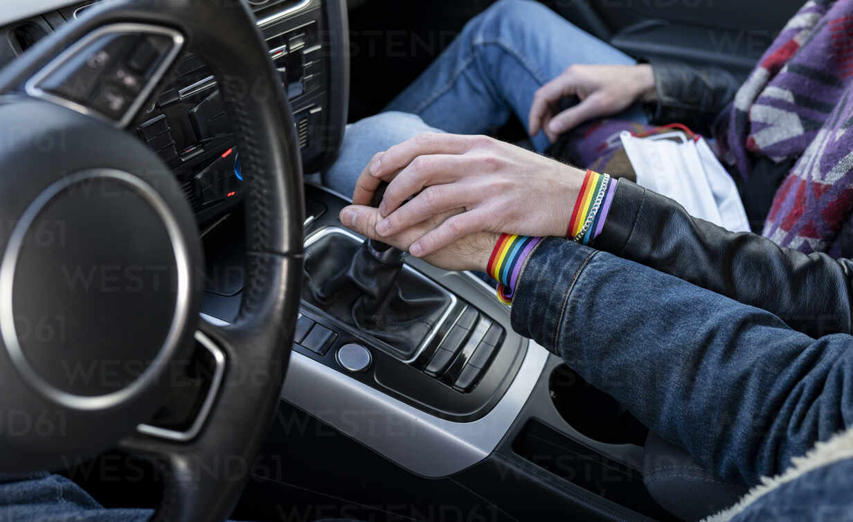 Hände von schwulen Freunden, die den Schaltknüppel im Auto halten,  lizenzfreies Stockfoto
