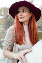 Close-up of thoughtful beautiful woman wearing hat in park - MRRF00780
