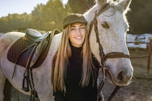 Portrait of woman with horse in paddock - GGGF00752