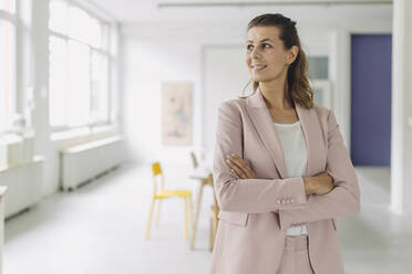 Smiling businesswoman standing in office - GUSF05001