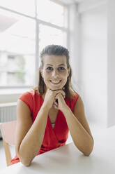 Porträt einer Geschäftsfrau im Büro sitzend - GUSF05016