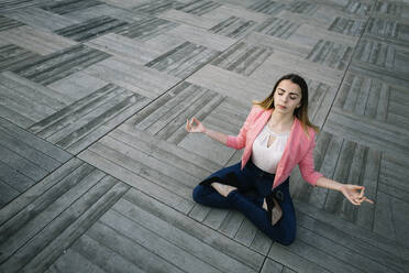 Young businesswoman meditating in city - XLGF00966