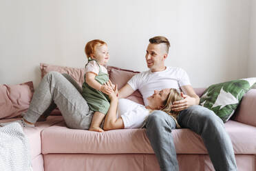 Glückliche Familie mit kleiner Tochter entspannt auf dem Sofa - VYF00388