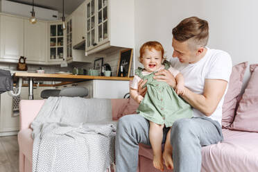 Vater und kleine Tochter auf dem Sofa - VYF00389