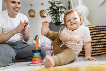 Father playing with baby daughter at home - VYF00406