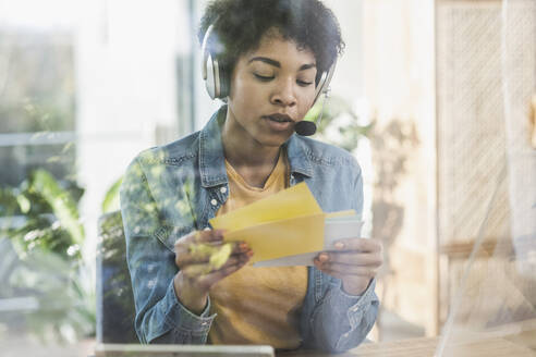 Woman with headset working at desk at home - UUF22446