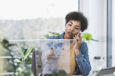 Frau telefoniert und benutzt transparentes Display zu Hause - UUF22451